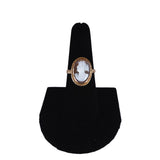 Ring with a cameo design on a black stand against a white background