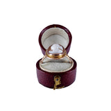 Gold ring with a heart-shaped gemstone in an open red jewelry box on a white background