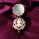 Cameo in a red jewelry box on a purple fabric background