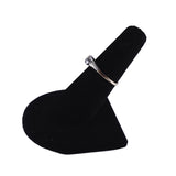 Silver ring on a black jewelry display stand against a white background