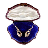 Gold earrings in an open jewelry box with a blue interior