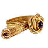 Gold ring with a purple gemstone on a white background