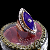 Decorative ring with a blue gemstone on a black background