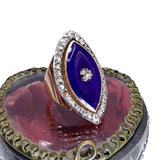 Ring with purple stone and rose gold accents on a red cushion