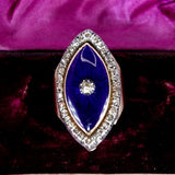 Decorative brooch with blue center and rhinestones on a purple velvet background