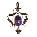 Ornate pendant with a purple gemstone on a white background