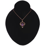 Necklace with a purple gemstone pendant on a black velvet stand against a white background