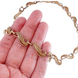 Gold bracelet on a hand with a white background