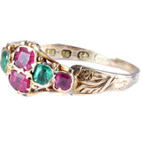Gold ring with green and pink gemstones on a white background