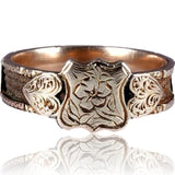 Gold ring with intricate design on a white background