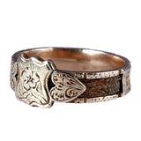Silver ring with intricate design on a white background