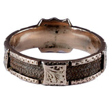 Silver ring with intricate design on a white background