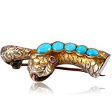 Gold snake-shaped brooch with turquoise stones and a purple gem on a white background