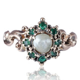Jewelry ring with pearl and emeralds on a white background