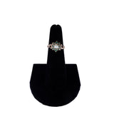 Ring on a black velvet stand against a white background