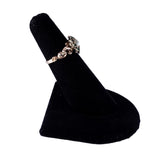 Gold ring on a black ring stand against a white background