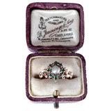 Vintage ring with emerald and diamond in a purple box on a white background