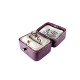 Purple jewelry box with a ring inside on a white background
