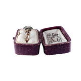 Open purple jewelry box with a ring inside on a white background