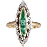 Gold ring with emerald and diamond design on a white background