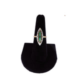 Ring with green gemstone on a black stand against a white background