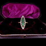 Vintage ring with emerald and diamond design in a purple velvet box
