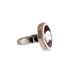 Silver ring with a circular design on a white background