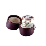 Silver ring with purple stone in an open purple jewelry box on a white background