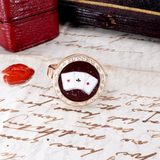 Ring with a design on a piece of paper with cursive writing
