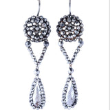 Pair of silver earrings with teardrop designs on a white background