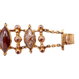 Gold bracelet with brown gemstones on a white background
