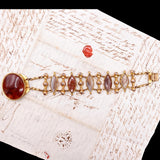 Gold bracelet with red stone on a historical document