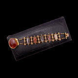Gold bracelet with colored stones on a black background