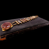 Vintage gold necklace with red stones on a black background