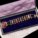 Gold bracelet with gemstones in a purple jewelry box