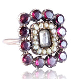 Decorative ring with gemstones and pearls on a white background
