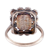 Silver ring with a central stone on a white background