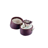 Purple jewelry box with a silver earring featuring a purple gemstone on a white background