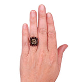 Hand wearing a decorative ring on a white background
