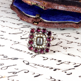 Vintage brooch with red gemstones and pearls on an old letter
