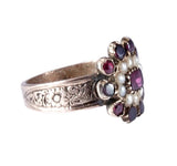 Silver ring with gemstones and pearls on a white background