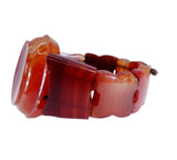 A carved stone bracelet made of polished agate in warm reddish-brown and amber tones, shown on a plain white background.