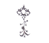An ornate silver-toned metal pendant or charm with a decorative scrollwork top and dangling vine-like filigree details, shown on a plain white background.