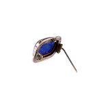 A single vintage-style earring with a teardrop-shaped blue stone in a silver-toned setting, featuring a small gold accent and a pin-back back, shown on a plain white background.