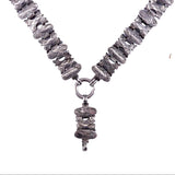 A textured silver-toned necklace featuring a Y-shaped arrangement of chunky, ridged oval links with a matching central pendant, shown against a plain white background.